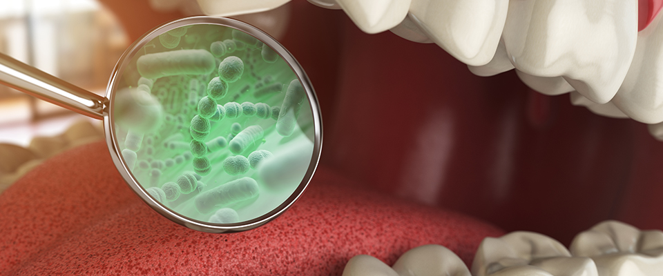A magnifying glass reveals a close-up image of bacteria in a CGI mouth